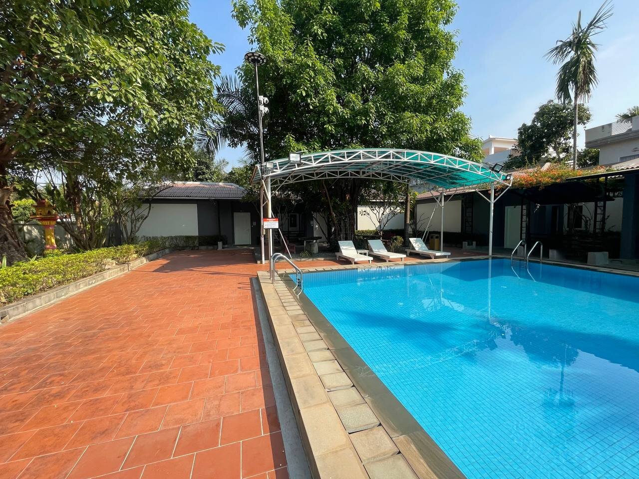 Sun loungers and shaded deck beside the shared pool at Bungalow 1955, Siem Reap