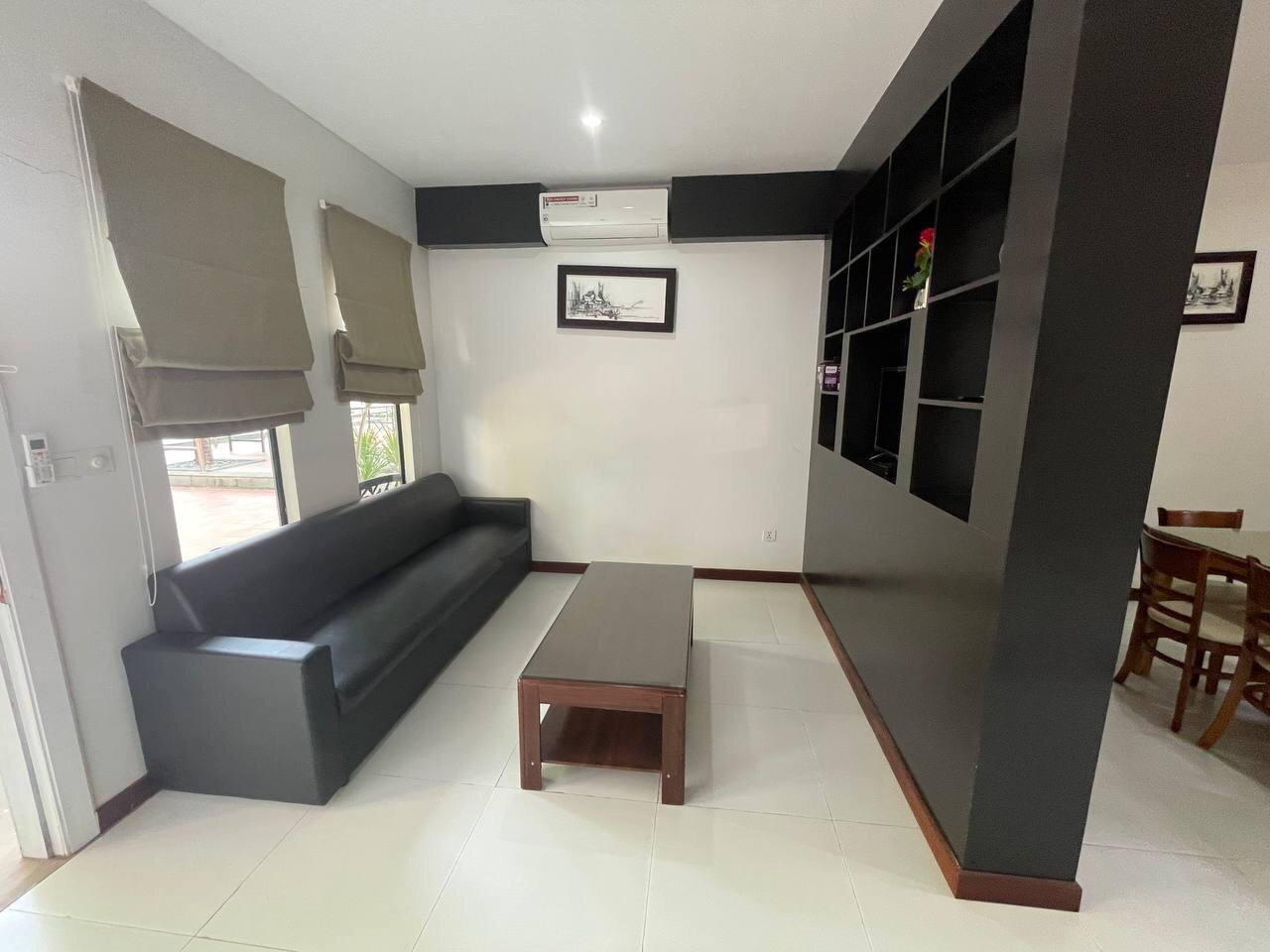 Living room with sofa and dining area in a Suite apartment at Bungalow 1955, Siem Reap